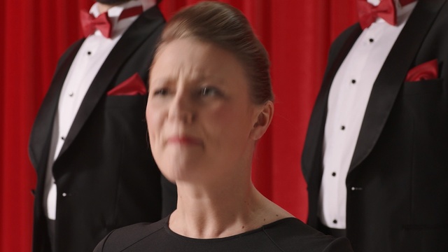 Video Reference: Red, Suit, Formal wear, Tuxedo, Outerwear, Neck, Smile, Jacket, Ear, Person