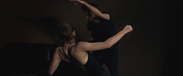Video Reference: Dancer, Dance, Choreography, Modern dance, Performance, Performing arts, Arm, Athletic dance move, Event, Human body, Person, Indoor, Man, Woman, Dark, Standing, Holding, Young, Front, Doing, Black, Hand, Playing, Shirt, Room, Board, Air, Remote, Night, Video, Wall, Elbow, Human face, Nude