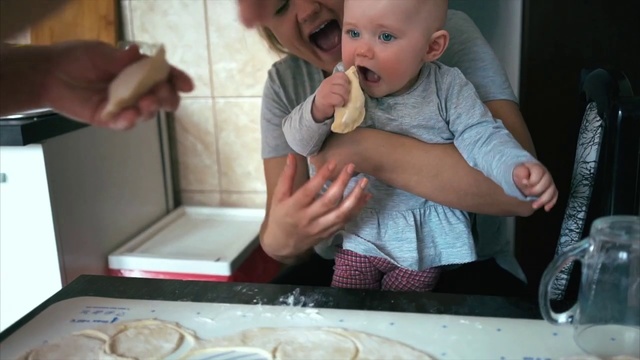 Video Reference: Child, Food, Mongolian food, Toddler, Dish, Baking, Cuisine, Comfort food, Person, Indoor, Table, Sitting, Baby, Front, Little, Small, Holding, Eating, Plate, Kitchen, Young, High, Large, Cake, Pizza, Mouth, Human face, Boy