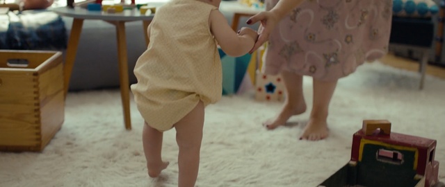 Video Reference: Child, Fun, Yellow, Toddler, Vacation, Summer, Play, Dress, Leisure, Barefoot, Person, Indoor, Little, Table, Boy, Young, Sitting, Small, Front, Playing, Baby, Holding, Girl, Living, Woman, Standing, Room, Cake, Eating, Birthday, Plate, Man, Floor