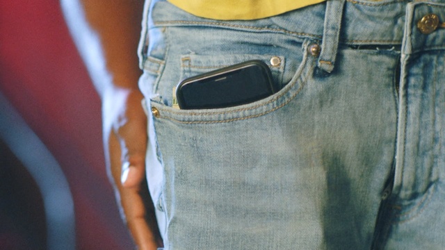 Video Reference: Denim, Jeans, Clothing, White, Pocket, Blue, Textile, Trousers, Waist, Style, Person, Man, Holding, Sitting, Small, Standing, Wearing, Hand, Table, Shirt, Boy, Glasses, Luggage, Game, Young, Yellow, Woman, Ball, Video, Playing, Phone, Suitcase, Room, Cat, Player, Plate, Belt, Handbag, Bag, Casual dress, Collar, Sleeve, Luggage and bags, Shorts, Zipper, Button, Shoulder bag, Trouser