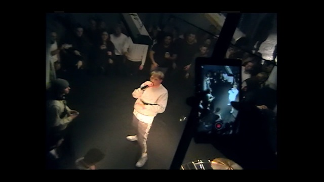 Video Reference: black, stage, darkness, performance, snapshot, performance art, fun, event, night, screenshot, Person