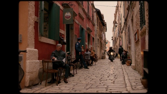 Video Reference: Building, Furniture, Window, Chair, Road surface, Sky, Neighbourhood, Travel, Flooring, Alley