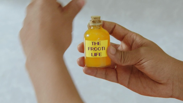 Video Reference: Yellow, Hand, Finger, Drink, Bottle, Nail, Orange soft drink, Liquid