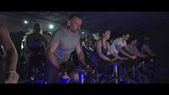 Video Reference: indoor cycling, social group, rock concert, crowd, audience, entertainment, darkness, stage, performance, fun