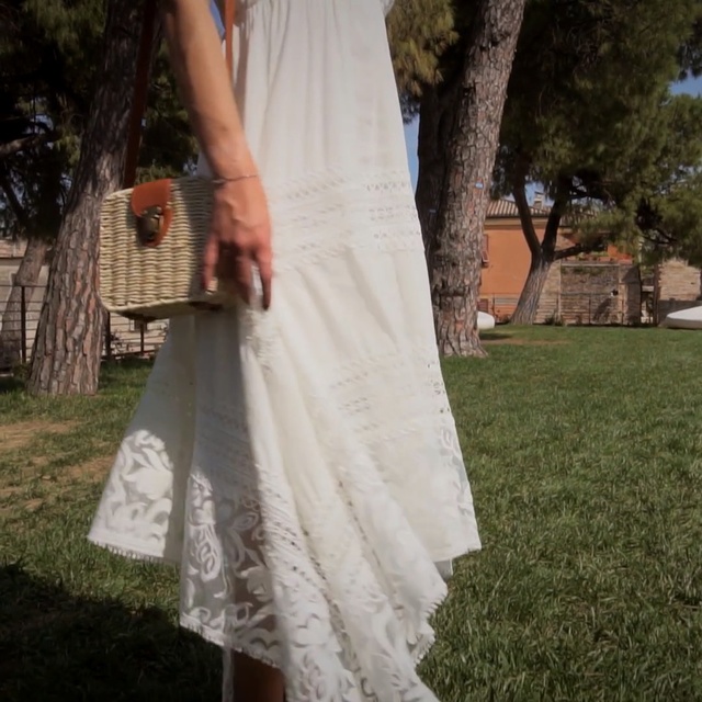Video Reference: White, Clothing, Dress, Gown, Shoulder, Lace, Formal wear, Wedding dress, Textile, Bridal party dress, Person, Grass, Outdoor, Man, Young, Holding, Woman, Standing, Girl, Little, Wearing, Yard, Throwing, Park, Field, Umbrella, Large, Covered, Walking, Red, Wedding, Tree, Bride