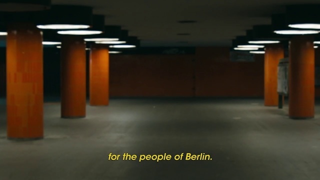 Video Reference: Floor, Building, Architecture, Parking, Column, Room, Flooring, City, Parking lot, Ceiling, Road, Outdoor, Orange, Street, Yellow, Sitting, Fire, Hydrant, Light, Night, Red, Traffic, Sign, Man, Black, White, Table, Standing, Woman, Sunset, Restaurant, Riding, Store, Blue, Parked, People, Dog, Bus, Text
