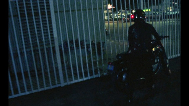 Video Reference: Urban area, Darkness, Vehicle, Night, Midnight, City, Metal, Person, Standing, Building, Man, Looking, Street, Dark, Sidewalk, Front, Black, Walking, Sitting, Light, Phone, Holding, Red, Room, People, Traffic, Door, White, Sheep