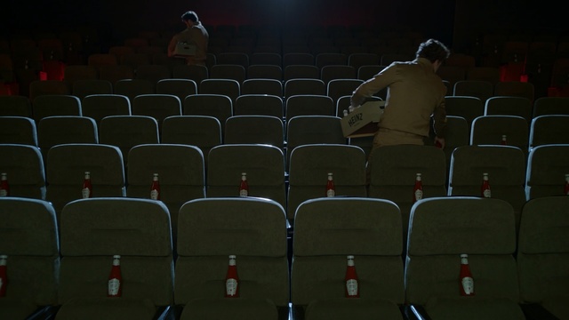 Video Reference: Audience, Auditorium, Darkness, Sport venue, Bottle, Ketchup, close up, sits, Movie theater