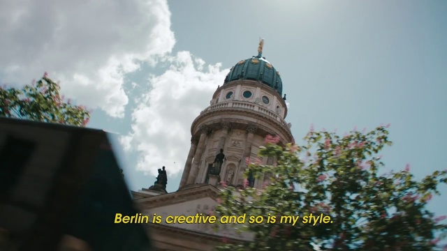 Video Reference: Landmark, Dome, Building, Sky, Architecture, Place of worship, Steeple, Historic site, Tree, Person, Outdoor, Tower, Clock, Large, Tall, Sign, Side, Brick, Walking, Old, White, Flying, Street, Red, Standing, Yellow, People, Man, Blue, City, Train, Cloud