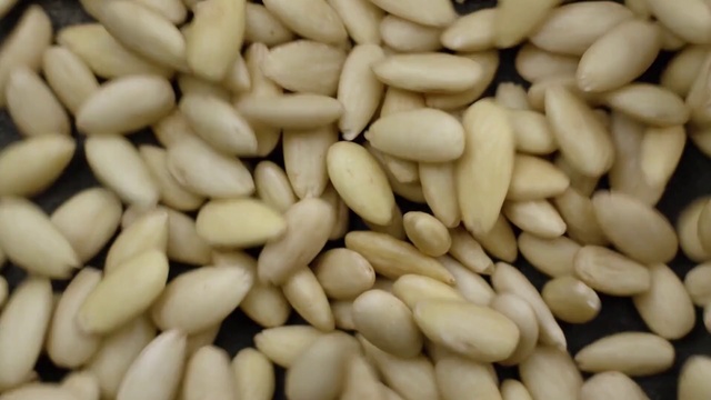Video Reference: Food, Pine nut, Vegetarian food, Ingredient, Cuisine, Plant, Seed, Nuts & seeds, Produce, Superfood, Nut, Fruit, Pile, Store, Several, Sitting, Photo, Large, Topped, Sliced, Fries, Chocolate, Counter, Banana, Bunch, Stacked, Plate, Ready, Close, Table, Green, Pan, Many, Group, Display, Oven, Arranged