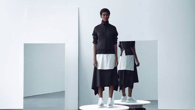 Video Reference: White, Clothing, Standing, Shoulder, Fashion, Sleeve, Joint, Footwear, Outerwear, Neck