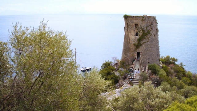 Video Reference: tree, promontory, sky, terrain, coast, escarpment, building, cliff, village, plant