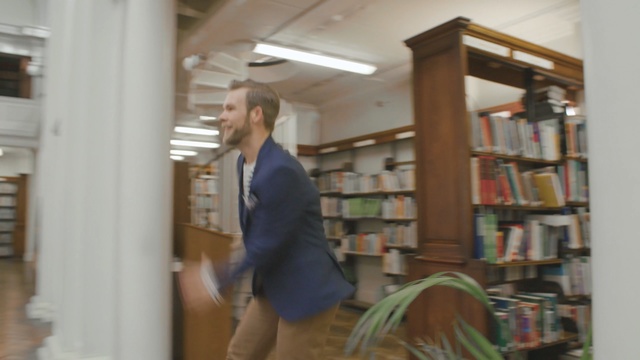 Video Reference: library, shelving, public library, bookcase, librarian, inventory, furniture, shelf, bookselling, floor, Person