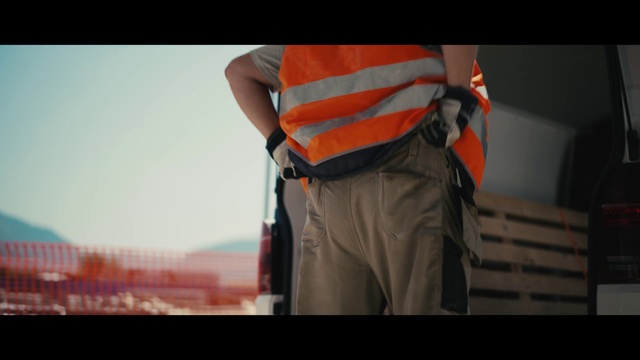 Video Reference: Orange, Standing, Arm, Human, Human body, High-visibility clothing, Personal protective equipment, Hand, Muscle, Photography