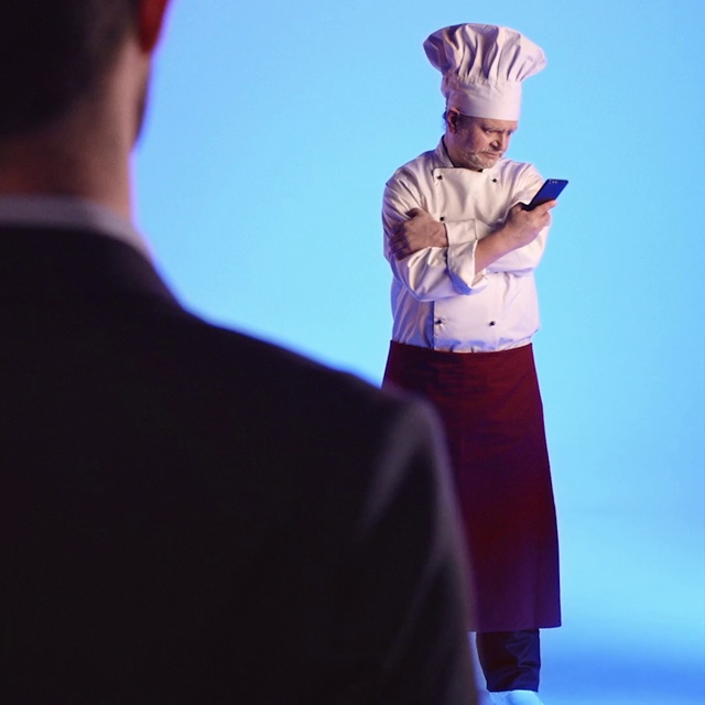 Video Reference: Gesture, Animation, Person, Standing, Man, Outdoor, Looking, Holding, Woman, Wearing, Front, Hand, Phone, Young, Flying, Shirt, Red, People, Hat, Playing, Umbrella, Street, Game, Blue, Sky, Clothing, Human face