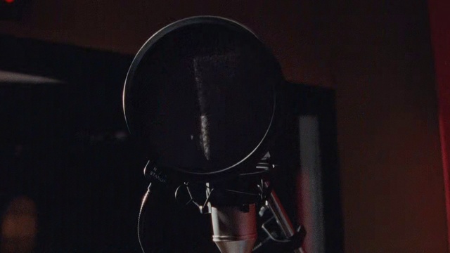 Video Reference: Microphone, Audio equipment, Technology, Darkness, Microphone stand, Electronic device, Photography, Room, Audio accessory, Indoor, Black, Sitting, Dark, Small, White, Table, Red, Mirror, Kitchen, Sign, Standing, Musical instrument, Headphones