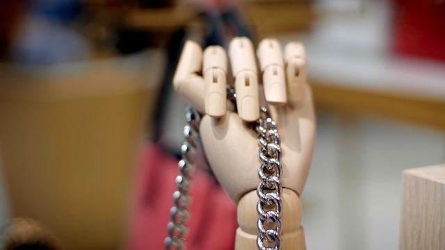 Video Reference: Chain, Hand, Finger, Fashion accessory, Nail, Arm, Jewellery, Metal, Person, Indoor, Table, Cup, Sitting, Food, Small, Desk, Using, White, Computer, Wooden, Keyboard, Remote, Necklace, Bead, Earrings