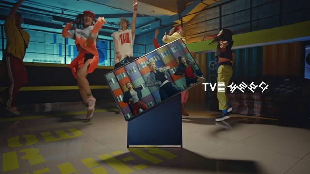 Video Reference: Room, Animation, Recreation, Floor, Indoor, Woman, Girl, Sitting, Looking, Table, Young, Standing, Holding, Playing, Court, Walking, Female, Computer, Man, Living, People, Group, Video, Doing, Stuffed, Person, Clothing, Footwear, Cartoon, Dance, Physical fitness, Screenshot