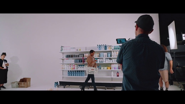 Video Reference: Snapshot, Photography, Glasses, Person, Man, Indoor, Standing, Woman, Looking, Front, Preparing, Holding, Screen, Table, People, Television, Monitor, Video, Kitchen, Playing, Computer, Laptop, Room, Group, Dog, Clothing, Text, Shelf
