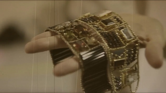 Video Reference: Jewellery, Bangle, Fashion accessory, Wrist, Bracelet, Finger, Hand, Metal, Watch, Indoor, Mirror, Table, Sitting, Cake, Reflection, Woman, Large, White, Clock, Standing, Kitchen, Man, Wall