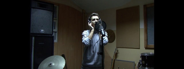 Video Reference: Personal protective equipment, Audio equipment, Mask, Gas mask, Microphone, Headgear, Costume, Technology, Photography, Electronic device, Person, Indoor, Standing, Man, Room, Front, Holding, Wearing, Black, Woman, Mirror, Kitchen, Refrigerator, Television, Door, Young, White, Video, Playing, Table, Remote, Living, Phone, Game, Wall, Clothing