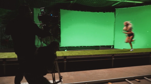 Video Reference: Green, Standing, Projection screen, Stage, Technology, Display device, Electronic device, Performance, Music venue, Film studio, Person