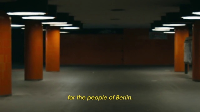 Video Reference: Light, Floor, Lighting, Architecture, Public space, Wall, Column, Flooring, Parking lot, Parking, Building, Orange, Yellow, Sitting, Street, Table, Red, Night, Man, Black, Room, White, Sign, Fire, Traffic, City, Standing, Bed, Blue, Hydrant, Text