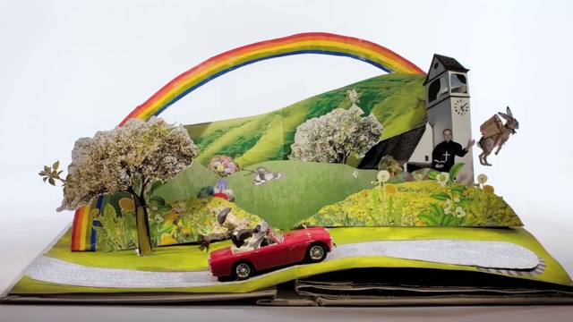 Video Reference: Vehicle, Automotive design, Tree, Automotive exterior, Car, Art, Person, Table, Indoor, Sitting, Food, Small, Different, Desk, Cake, Black, Computer, Colorful, Plate, White, Red, Bed, Rainbow, Land vehicle