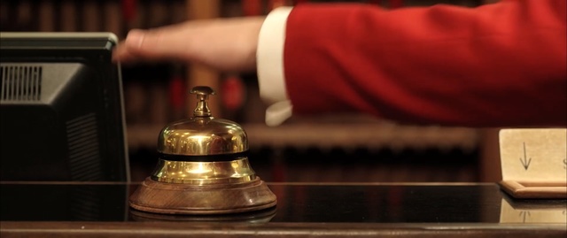 Video Reference: hotel, man, hand, red jacket, bell, reception, Person