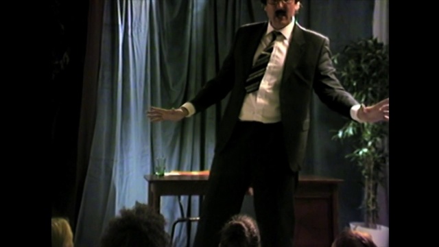 Video Reference: Suit, Formal wear, Speech, Performance, Public speaking, Gentleman, Male, Orator, Event, Tuxedo