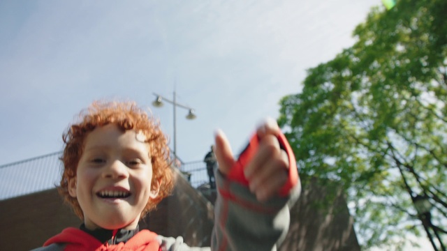 Video Reference: Child, Fun, Happy, Tree, Finger, Leaf, Travel, Sky, Smile, Hand, Person, Outdoor, Little, Young, Holding, Boy, Standing, Small, Girl, Wearing, Front, Man, Red, Skiing, Large, Snow, Riding, Cake, White, Playing, Human face, Clothing, Toddler, Outdoor object