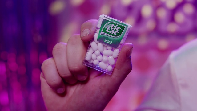 Video Reference: Hand, Sweetness, Finger, Confectionery, Person, Cellphone, Phone, Holding, Remote, Control, Small, Food, Drug, Pharmaceutical drug, Pill, Candy, Cosmetics, Medicine, Nail