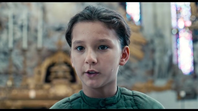 Video Reference: Face, Hair, Facial expression, Forehead, Chin, Cheek, Nose, Head, Eyebrow, Human, Person, Building, Young, Front, Little, Table, Smiling, Boy, Looking, Holding, Sitting, Small, Shirt, Wearing, Food, Standing, Girl, Green, Close, Street, White, Pizza, Plate, Woman, Man, Phone, City, Blue, Human face, Child, Toddler, Clothing, Portrait