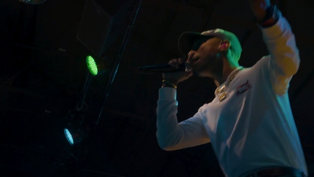 Video Reference: Performance, Entertainment, Green, Music, Performing arts, Singing, Music artist, Musician, Stage, Concert, Person, Man, Holding, Indoor, Playing, Hand, Front, Ball, Standing, Racket, Player, Fire, Shirt, Using, Swinging, Young, Room, Woman, Game, Wearing, Video, White, Remote, Court, Microphone, Band, Live music, Gig, Musical instrument