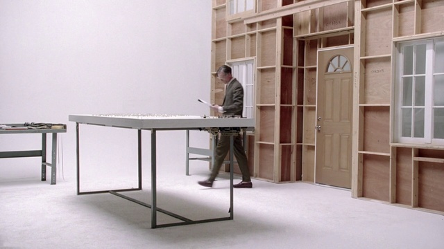 Video Reference: Desk, Furniture, Table, Computer desk, Room, Writing desk, Material property, Interior design, Floor, Flooring, Person