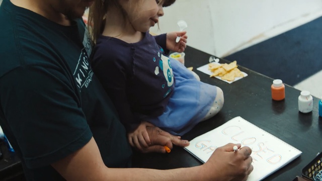 Video Reference: Learning, Writing instrument accessory, Hand, Writing, Homework, Student, Child, Person, Indoor, Table, Sitting, Woman, Food, Holding, Computer, Using, Man, Laptop, Young, Desk, Plate, Game, Cake, Blue, Eating, Playing, People, Black, Cutting, Video, Keyboard, Standing, Clothing, Fast food