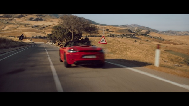 Video Reference: Land vehicle, Vehicle, Car, Automotive design, Performance car, Luxury vehicle, Road, Supercar, Mid-size car, Outdoor, Scene, Red, Driving, Street, Mountain, Highway, Desert, Truck, Traffic, Traveling, View, Riding, Motorcycle, Country, Orange, Parked, Stop, Sign, White, Man, Sky, Wheel, Way, Text, Automotive