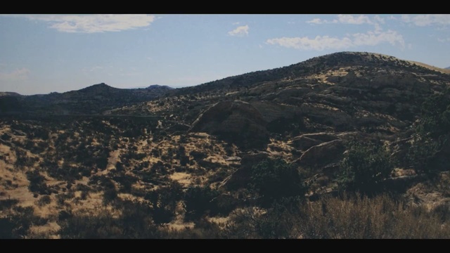 Video Reference: sky, mountainous landforms, hill, mountain, ridge, escarpment, shrubland, highland, geological phenomenon, fault