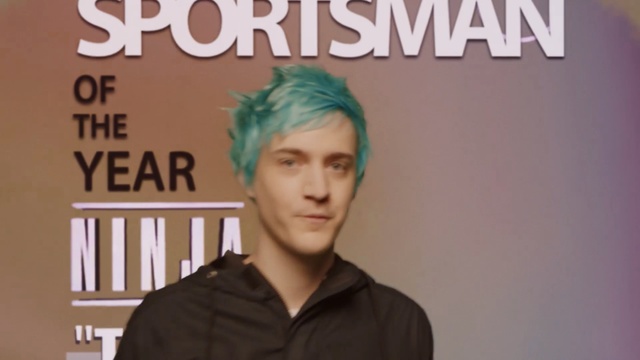 Video Reference: Hair, Forehead, Text, Hairstyle, Chin, Font, Cool, Album cover, Photography, Photo caption, Person, Indoor, Woman, Front, Holding, Man, Standing, Young, Sign, Shirt, Black, Table, Birthday, Suit, Wall, Human face, Book, Clothing, Poster