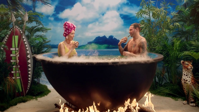 Video Reference: Jacuzzi, Bathtub, Bathing, Vacation, Fun, Leisure, Resort, Art, Outdoor, Table, Front, Woman, Sitting, Man, Large, Standing, Vase, Flower, Cake, Food, Holding, People, Red, Water, Group, White, Plate, Swimming, Summer, Person, Human face, Vessel, Plant, Porcelain