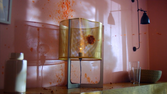 Video Reference: room, interior design, wall, lighting, table, furniture, home, house, glass, lighting accessory, Person