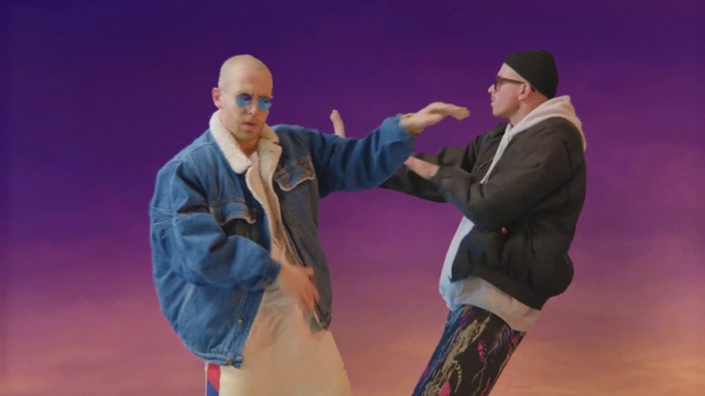 Video Reference: Fashion, Purple, Performance, Fun, Animation, Gesture, Performing arts, Action figure, Screenshot, Dance, Person, Man, Outdoor, Holding, Standing, Racket, Court, Hand, Ball, Player, Wearing, Woman, Young, Game, Phone, Table, Playing, Water, Board, Street, People, White, Clothing, Human face