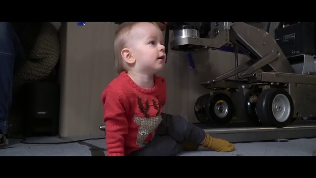 Video Reference: Child, Facial expression, Audio equipment, Loudspeaker, Toddler, Arm, Male, Cheek, Photography, Technology