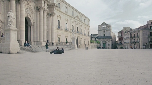 Video Reference: town square, plaza, town, building, tourist attraction, palace, facade, classical architecture, city, tourism, Person
