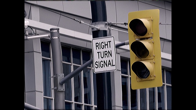 Video Reference: Traffic light, signaling device, Yellow, Lighting, Traffic sign, Light fixture, Signage, Sign, Font, Street sign, Person
