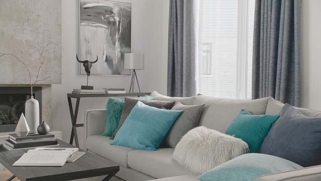 Video Reference: living room, room, interior design, home, furniture, wall, couch, textile, window, window treatment, Person