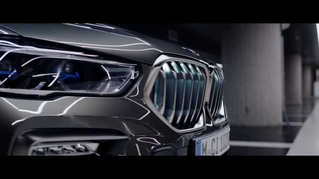 Video Reference: Land vehicle, Vehicle, Car, Headlamp, Automotive design, Bmw, Grille, Light, Automotive lighting, Helmet, Silver, Sitting, Black, Street, Parked, White, Man, City, Riding, Mirror, Automotive, Headdress, Auto part, Control panel
