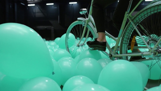Video Reference: Green, Balloon, Party supply, Turquoise, Architecture, Leisure, Vehicle, Games, Table, Chair, Food, Sitting, Bowl, Woman, Parked, Room, Plate, Motorcycle, Large, Computer, Desk, White, Holding, Blue, Cake, Man, Standing, Kitchen, Display, Umbrella, Tub, Boat, Sink, People, Group, Wheel, Bicycle, Land vehicle