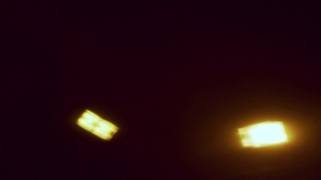 Video Reference: Automotive lighting, Light, Lighting, Yellow, Amber, Auto part, Headlamp, Photography, Darkness, Night, Dark, Monitor, Television, Watching, Red, Background, Looking, Front, Set, Flying, Lit, Sun, Screen, Bright, Large, Sunset, Close, Blurry, Room, Street, Air, Riding, Sign, Bed, Man, White, Street light, Abstract, Moon, Image, Blur